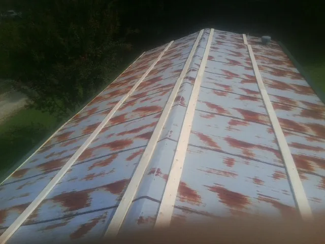 Rusted metal roof panels with new wood purlins before replacement — Storm Damage Roof Repair in Ruthville by Roofing Brothers