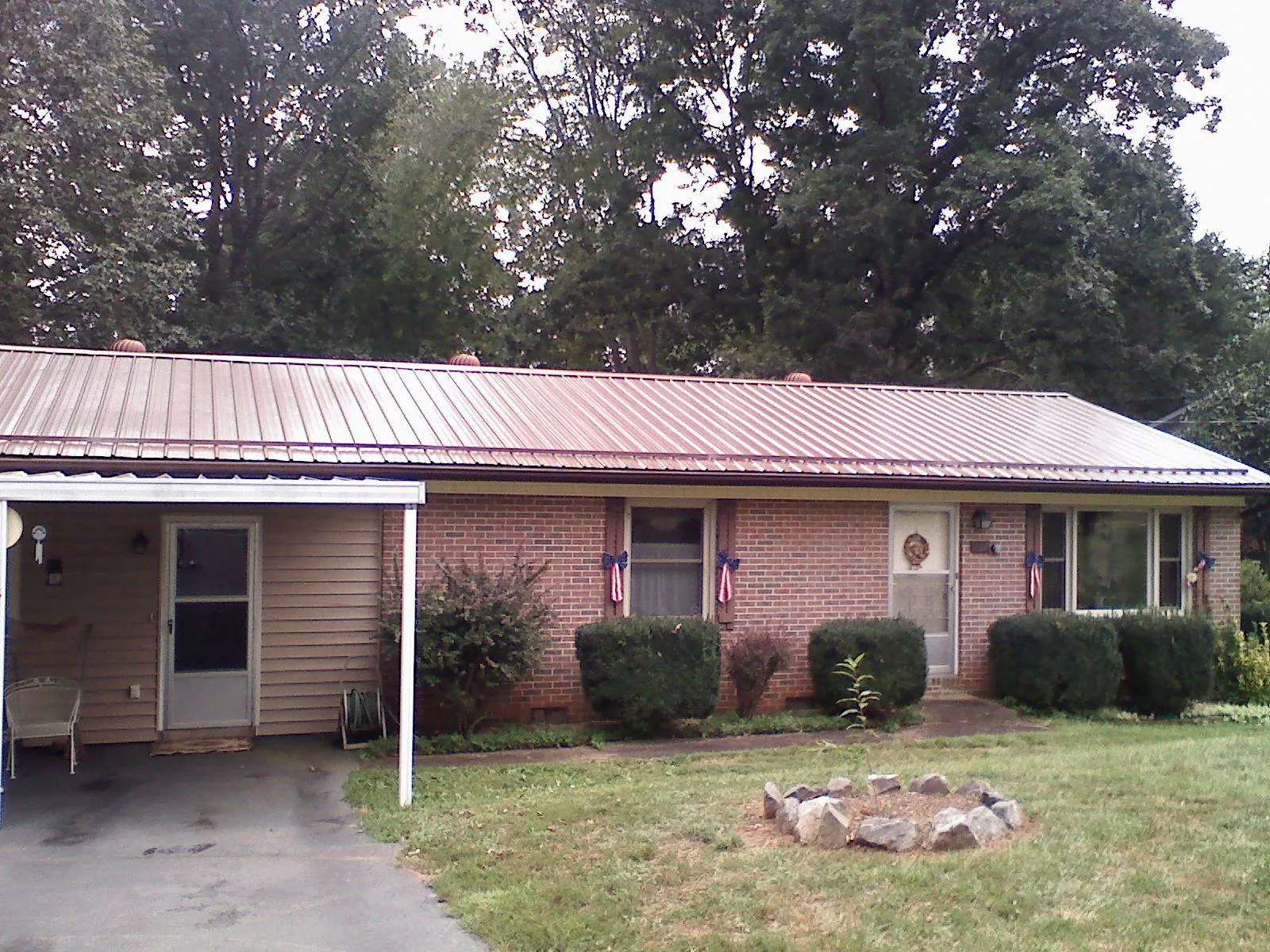 Bronze metal roof and carport on a brick ranch home — Roof Repair work by our crew in Ruthville